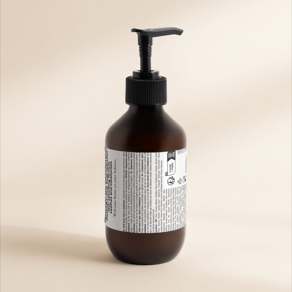 An amber brown pump bottle with a black dispenser cap and a white product label, photographed against a warm beige studio background.