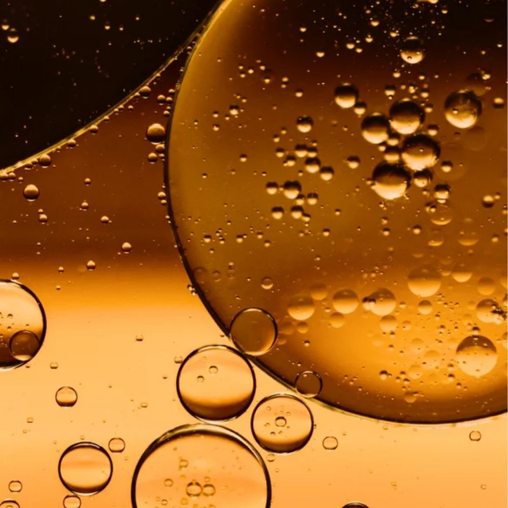 Close-up of oil and water bubbles on a yellow background