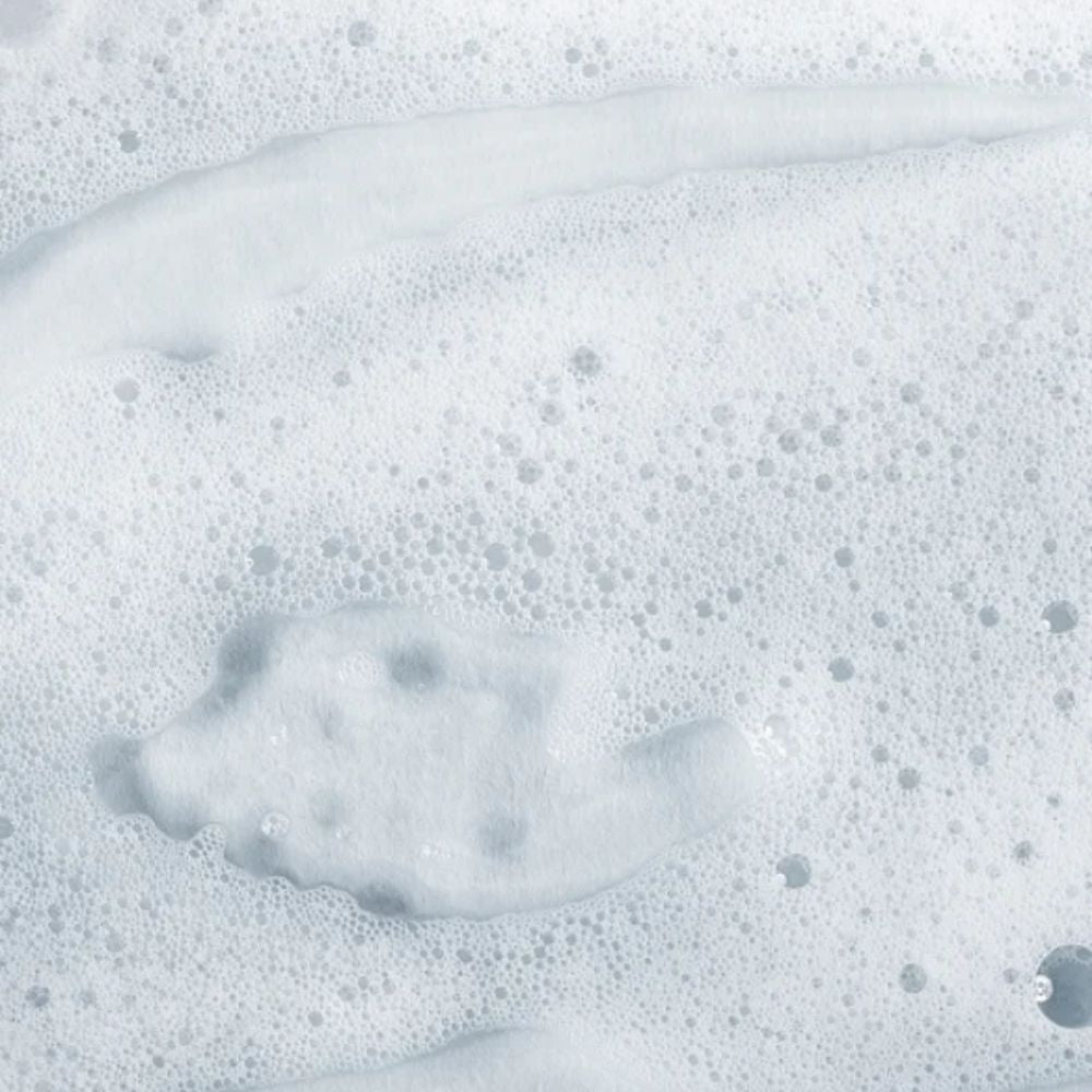 Close-up of thick white foam with dense bubbles and soft translucent ridges.