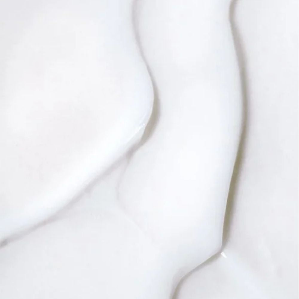 A close-up of smooth white fabric with soft folds and a matte texture.