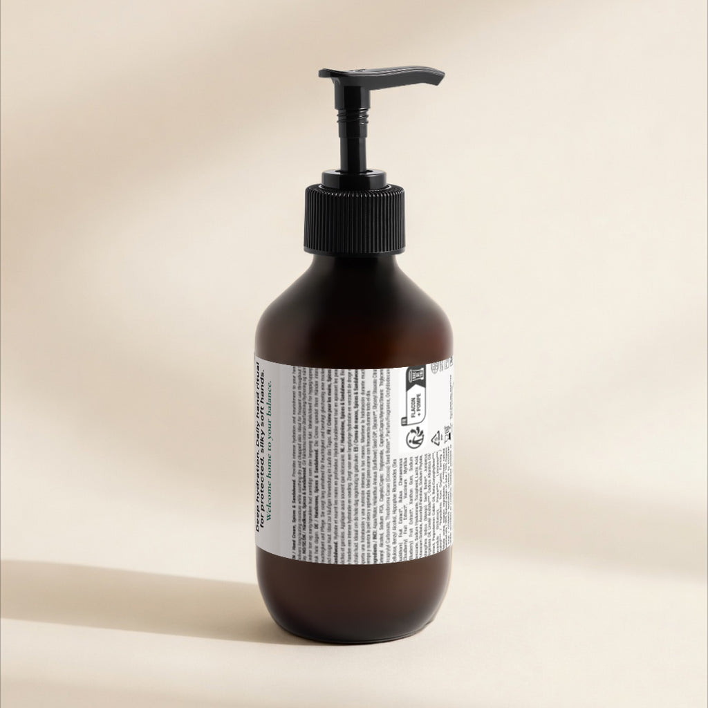 An amber glass pump bottle with a black dispenser and a white product label, photographed against a warm beige background.